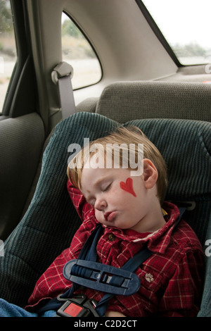 Ein 3 Jahre alter Junge schlafend in seinem Autositz während Nap time.after einen Familienausflug. Stockfoto