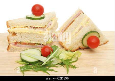 Schinken und Käse-Club-Sandwich mit Salat garniert auf einem Holzbrett Stockfoto