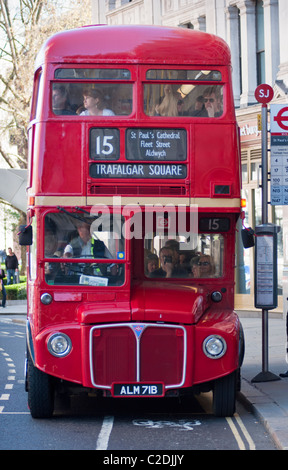 A red double decker Routemaster bus front view full of passangers, at a bus stop near St Pauls, London, England. Stockfoto