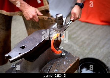 Eisen-Fälscher arbeitet an einem heißen Hufeisen in Anglesola. LLeida. Spanien. Stockfoto