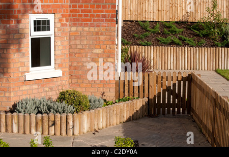 Holztor, Zaun und Einfassung in einem neu angelegten Garten vor einem Haus in England. Stockfoto