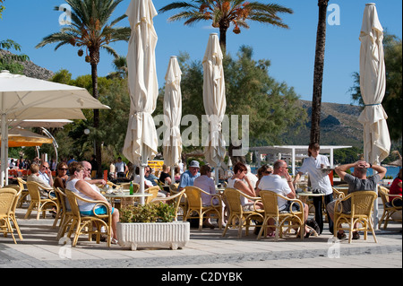 Urlauber, die Entspannung vor einem Café-Restaurant in der hübsche spanische Ferienort Puerto Pollensa. Stockfoto