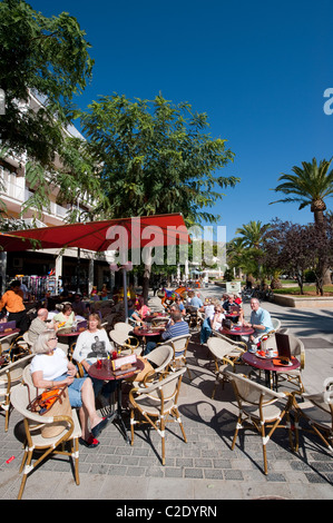 Urlauber, die Entspannung vor einem Café-Restaurant in der hübsche spanische Ferienort Puerto Pollensa. Stockfoto