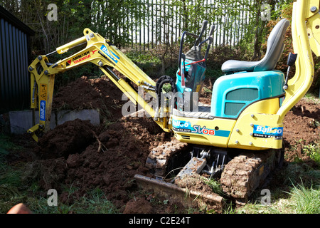 eingestellt von Mikro Minibagger ausheben kleinen Garten im Vereinigten Königreich Stockfoto