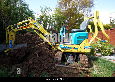 eingestellt von Mikro Minibagger ausheben kleinen Garten im Vereinigten Königreich Stockfoto