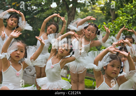 Kleine Mädchen aus einer klassischen Ballettschule posiert für eine Reihe von Bildern in einem Stadtpark. Stockfoto