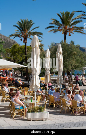 Urlauber, die Entspannung vor einem Café-Restaurant in der hübsche spanische Ferienort Puerto Pollensa. Stockfoto