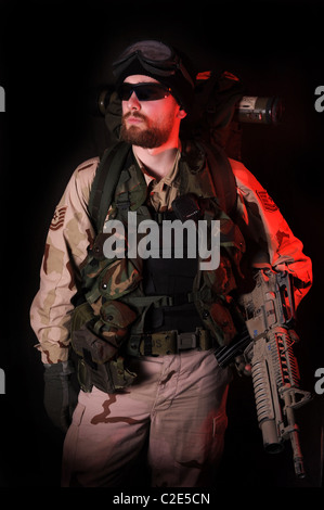 Eine stimmungsvolle Aufnahme eines US Special Forces Soldaten in der Nacht beleuchtet durch weiße Flut und rote Warnlampe. Afghanistan. Irak. Stockfoto