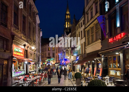 Bars und Restaurants in der Nacht auf der Rue du Marche Aux Fromages mit dem Turm des Hotel de Ville hinter, Brüssel, Belgien Stockfoto