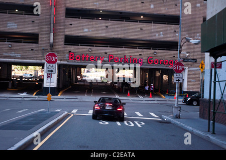 Eintritt zum Battery Parking Garage in Manhattan, New York City, in der Nähe des Battery Park. Ein Auto nähert sich der Garage unter einem Neonschild. Stockfoto