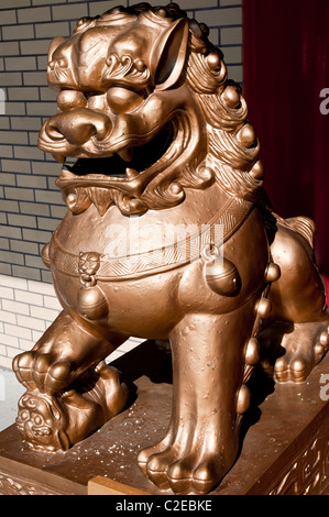 Eine Schutzstatue aus Metall in einem buddhistischen Tempel des chinesischen Mahayana in Chinatown, Manhattan, New York City. Goldene buddhistische religiöse Skulptur. Stockfoto