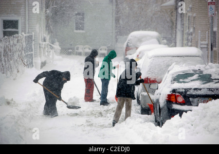 Menschen Schaufel Schnee von parkenden Autos während eines Schneesturms Winter in Boston, Massachusetts Stockfoto