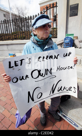 Eine Frau hält ein Schild während einer Anti-Atom-Kundgebung vor dem State House in Boston, Massachusetts Stockfoto