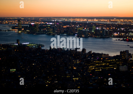 Luftaufnahme von Manhattan bei Nacht mit Stadtlichtern über dem Hudson River, New York City, USA. Atemberaubende Skyline in der Abenddämmerung und urbane Landschaft. Stockfoto