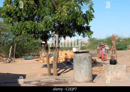 Indische Frauen in ländlichen Gebieten mit Töpfen auf Kopf, Wasser aus einem Brunnen in Gujarat zu sammeln Stockfoto