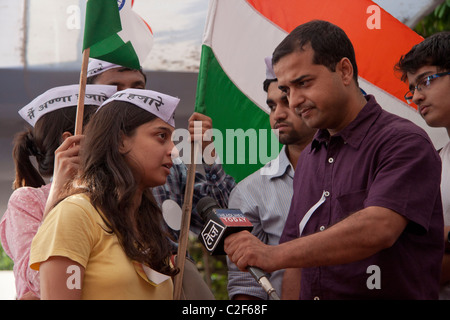 Eine junge Dame Anhänger der Anna Hazares Kampf gegen die Korruption wird durch einen TV-Kanal in Azad Maidan, Indien interviewt. Stockfoto