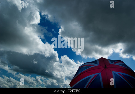 Austritt, Union Jack Regenschirm gegen eine trübe, stürmischen Himmel. Britische Wirtschaft / Wetter-Konzept. Stockfoto
