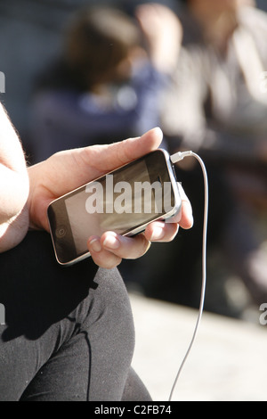 Detail der Frau mit Iphone in Sonne im freien Stockfoto