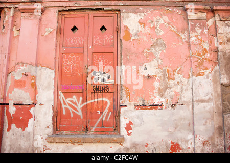 Graffiti auf ein paar externe georgianische Fenster Fensterläden, Fournier Street, Spitalfields, London, UK. Stockfoto