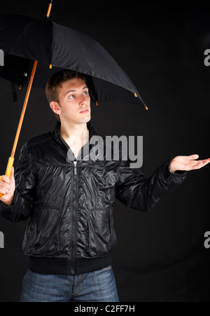 Junger Mann mit Regenschirm. Stockfoto