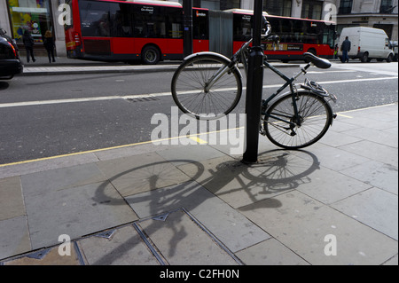 Fahrrad angekettet an einer Londoner Straße post Stockfoto