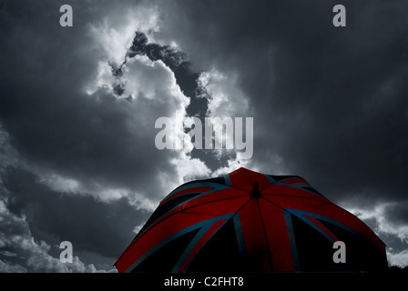 Austritt, Union Jack Regenschirm gegen eine trübe, stürmischen Himmel. Britische Wirtschaftskonzept. Stockfoto