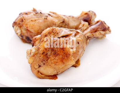 zwei knusprig gebratene Hähnchenschenkel auf einem weißen Teller Stockfoto