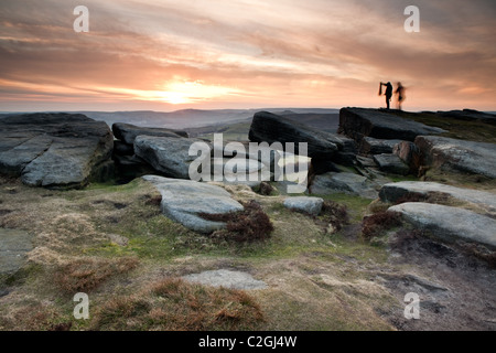 Zwei Kletterer in der Silhouette auf Stanage Edge in den Hauptverkehrszeiten Bezirk Derbyshire East Midlands England Stockfoto