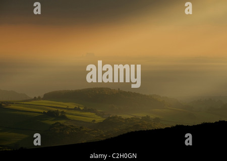 am frühen Morgen Sonnenstrahlen durchbrechen den Himmel über Exmoor in der Nähe von Porlock Stockfoto