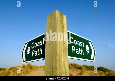 Ein Küsten-Wanderweg-Zeichen auf dem South West Coast Path in North Devon, UK vor dem Hintergrund der Dünen und blauer Himmel Stockfoto