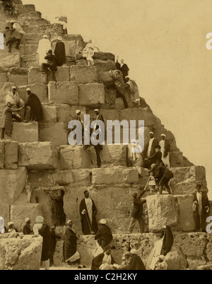 Mehrere Menschen versammelten sich am Fuße der großen Pyramide, andere Klettern Stockfoto