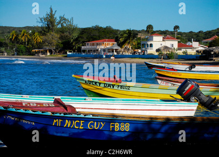 Angelboote/Fischerboote verankert in Frenchman es Bay in Treasure Beach, mit Golden Sands Beach Resort im Hintergrund, St. Elizabeth, Jamaika Stockfoto