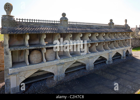 Die ungewöhnliche Cotswold Kalkstein Bee Shelter auf dem Kirchhof von St. Mary the Virgin in Hartpury, Gloucestershire, England, UK Stockfoto