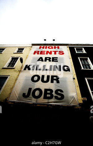 Schild mit der Aufschrift "hohe mieten sind unsere Arbeitsplätze töten" schwebt über einem Geschäft auf Dublins Grafton Street in Irland. Stockfoto