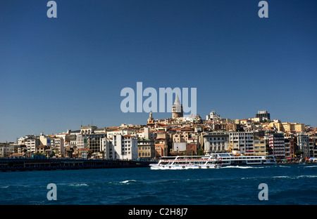 Ein Blick über das Goldene Horn in Richtung der Galata-Turm in Istanbul mit einer Fähre im Vordergrund. Stockfoto