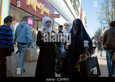 Eine Gruppe von jungen muslimischen Shopper, Essen ein Eis auf der Oxford Street London UK Stockfoto