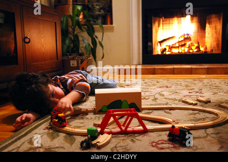 Kleiner Junge spielt mit Spielzeug-Eisenbahnen Stockfoto