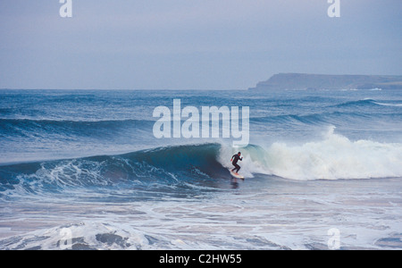 Surfer auf einer Welle am Strand East, Portrush, County Antrim, Nordirland. Stockfoto