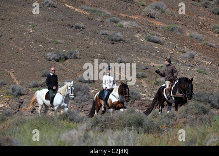 Gruppe von Personen, die Reiten durch den Berg von Fuerteventura, Spanien. Stockfoto