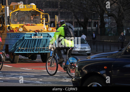 Ein Mann, Radfahren auf einem Boris Bike unter Verkehr in London Stockfoto