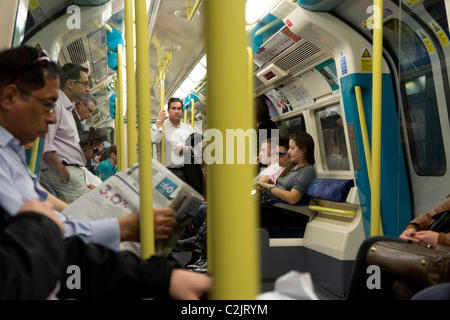 Fahrgäste lesen Zeitungen in einer Londoner U-Bahn u-Bahn Zug, London, England, UK Stockfoto