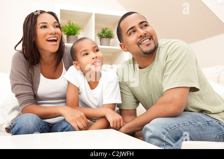 Glückliche afroamerikanische Familie, Eltern und Sohn sitzen auf einem Sofa zu Hause lachen und Lächeln Stockfoto