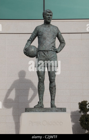 Die Peter Osgood Statue durch die Westtribüne, Stamford Bridge Stadium, Heimat der Chelsea Football Club, West London, England. Stockfoto