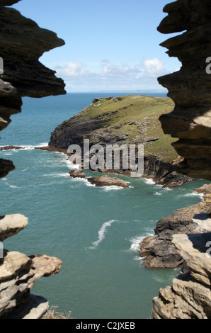 Blick auf das Meer und die Landzunge durch einen Stein Fenster in Tintagel, Cornwall, England Stockfoto