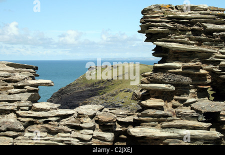 Blick auf Land und Meer durch eine alte Fenster auf Tintagel Castle, Cornwall, England Stockfoto