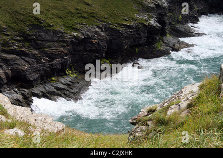 Wellen gegen Felsen in Tintagel, Cornwall, England Stockfoto