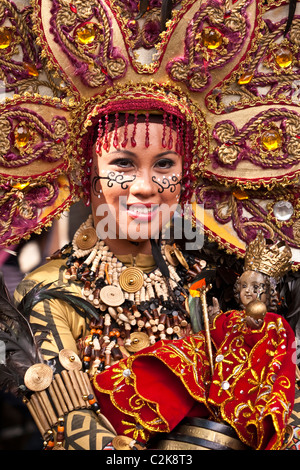 Ein Porträt einer Dame in Perlen Kostüm und Perlen Kopfschmuck hält ein Sto. Nino-Statuette. Stockfoto