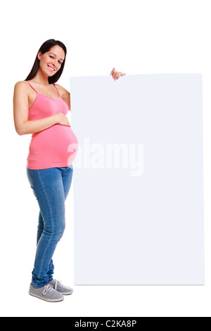Foto von einer attraktive Brünette Frau, die 32 Wochen schwanger mit einem leeren Schild, isoliert auf einem weißen Hintergrund. Stockfoto