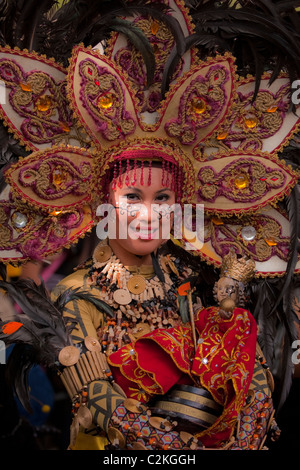 Ein Porträt einer Dame in Perlen Kostüm und Perlen Kopfschmuck hält ein Sto. Nino-Statuette. Stockfoto