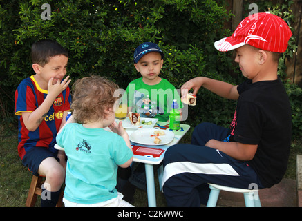 Kinder mit einem Picknick im Garten. Stockfoto